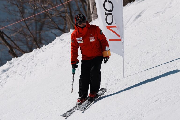 スクールの旗の横でコースを整えるスタッフ