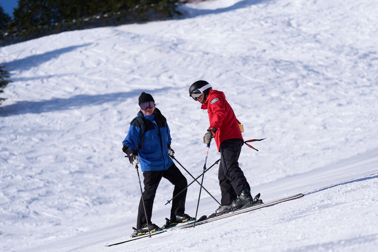 Coach and guest on a sunny slope